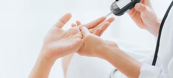 a medical professional checking a woman's A1C. 