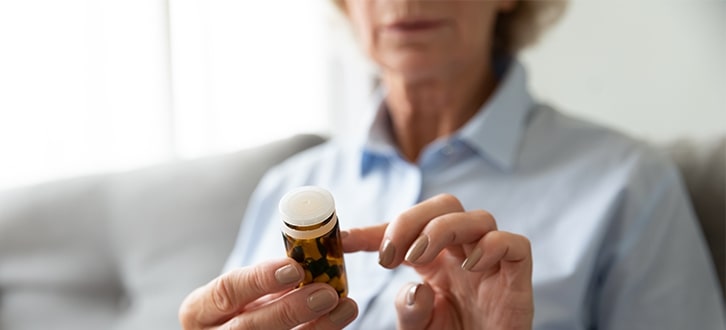 Una mujer mirando la etiqueta de su medicamento de CenterWell Pharmacy