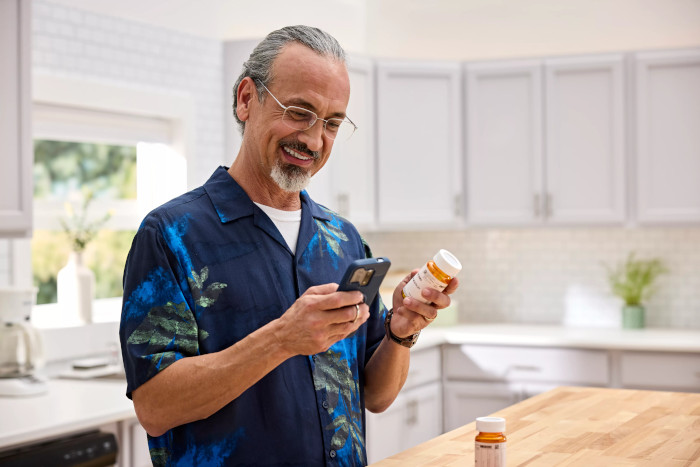 Un nuevo cliente de CenterWell Pharmacy usando su teléfono celular para comenzar a administrar sus medicamentos en línea.