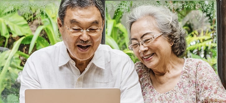 Hombre y mujer al aire libre con su computador portátil para pedir un resurtido de sus medicamentos recetados con CenterWell Pharmacy