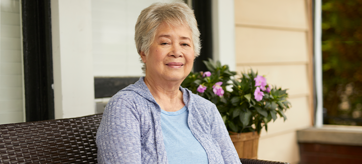 A woman sitting outside on her porch 