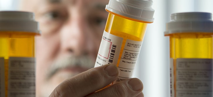 Man looking at medication in cabinet