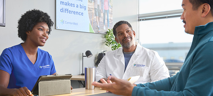 Nurse, pharmacist and doctor talking around a table in an office meeting room.