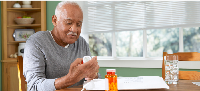 man reading prescription bottle