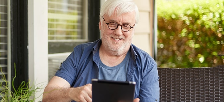 Hombre sonriente usando una tablet electrónica
