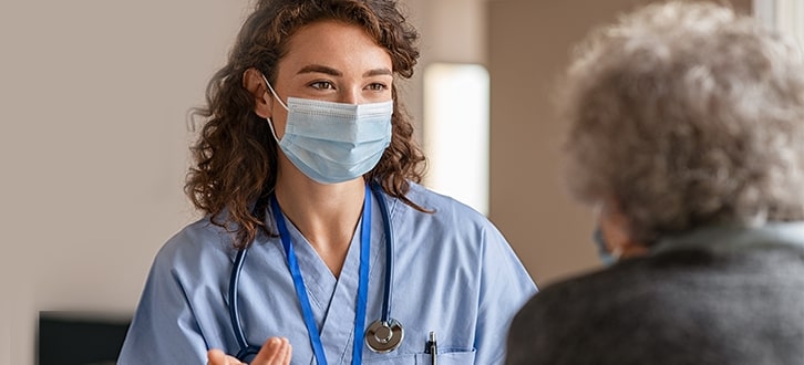 A nurse talking to a patient about COVID-19 vaccines 