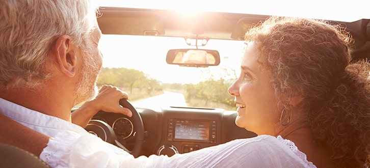 older couple enjoying a summer drive