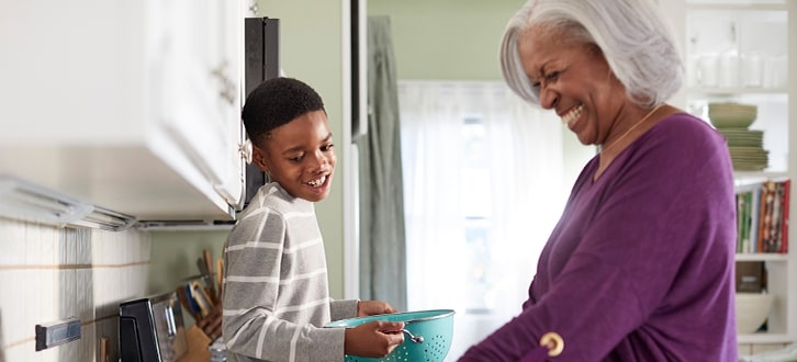 A woman in the kitchen with her grandson