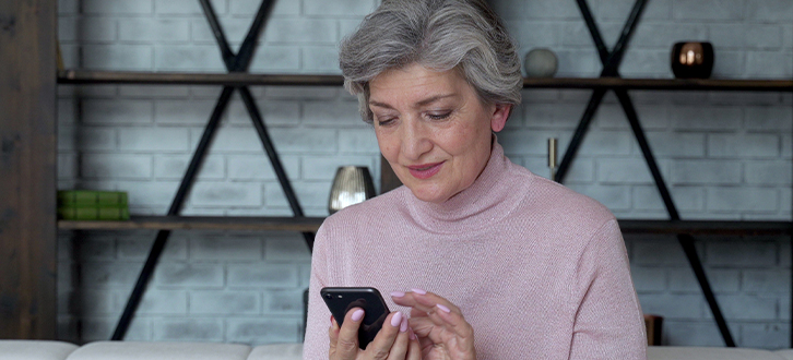 Older woman checking CenterWell Pharmacy app on her mobile phone