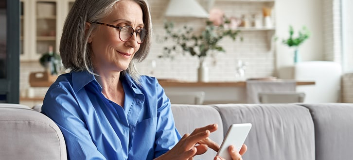 Woman tapping on phone to check med reminders